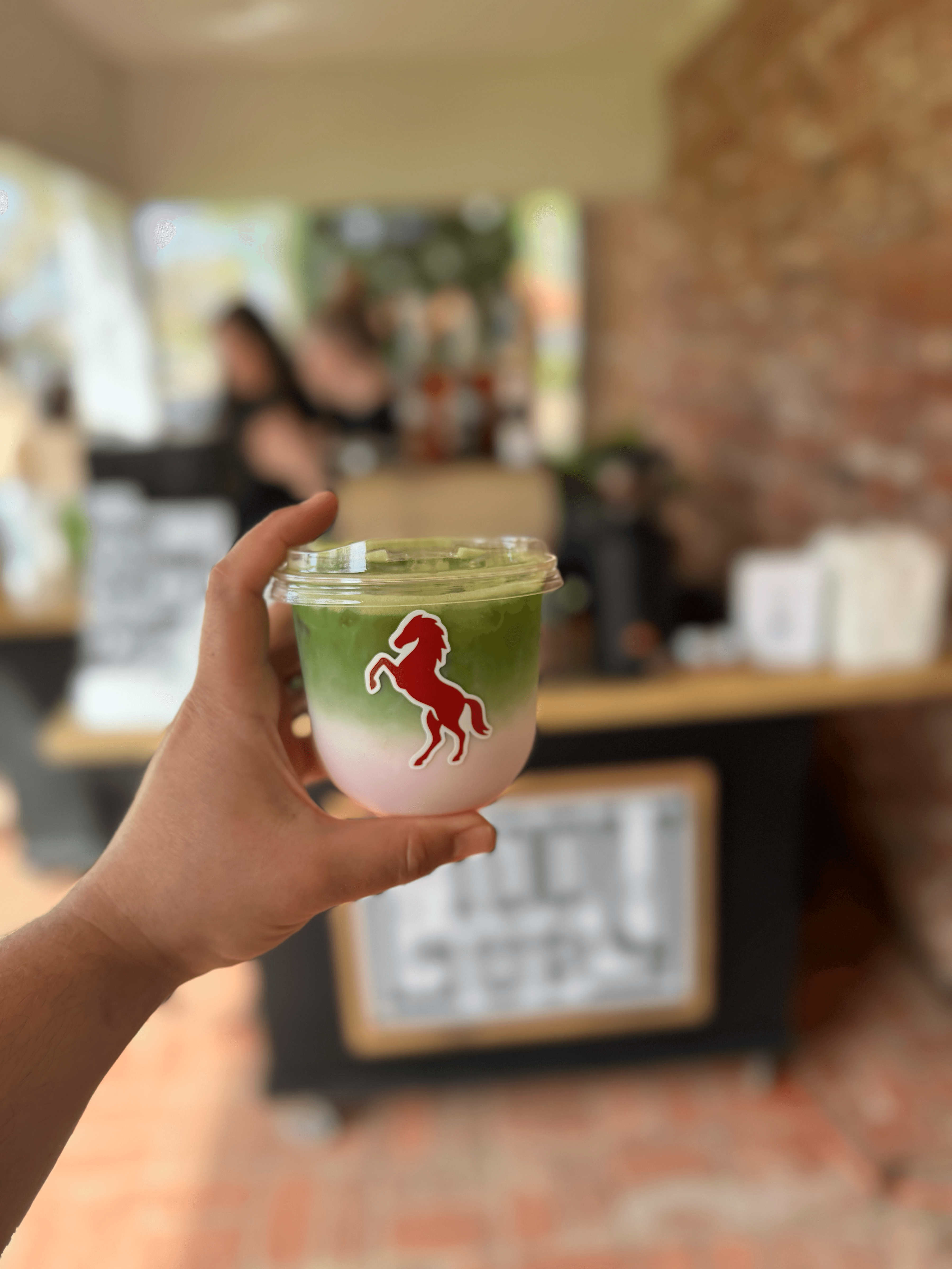A friendly barista pouring smooth latte art at a coffee cart