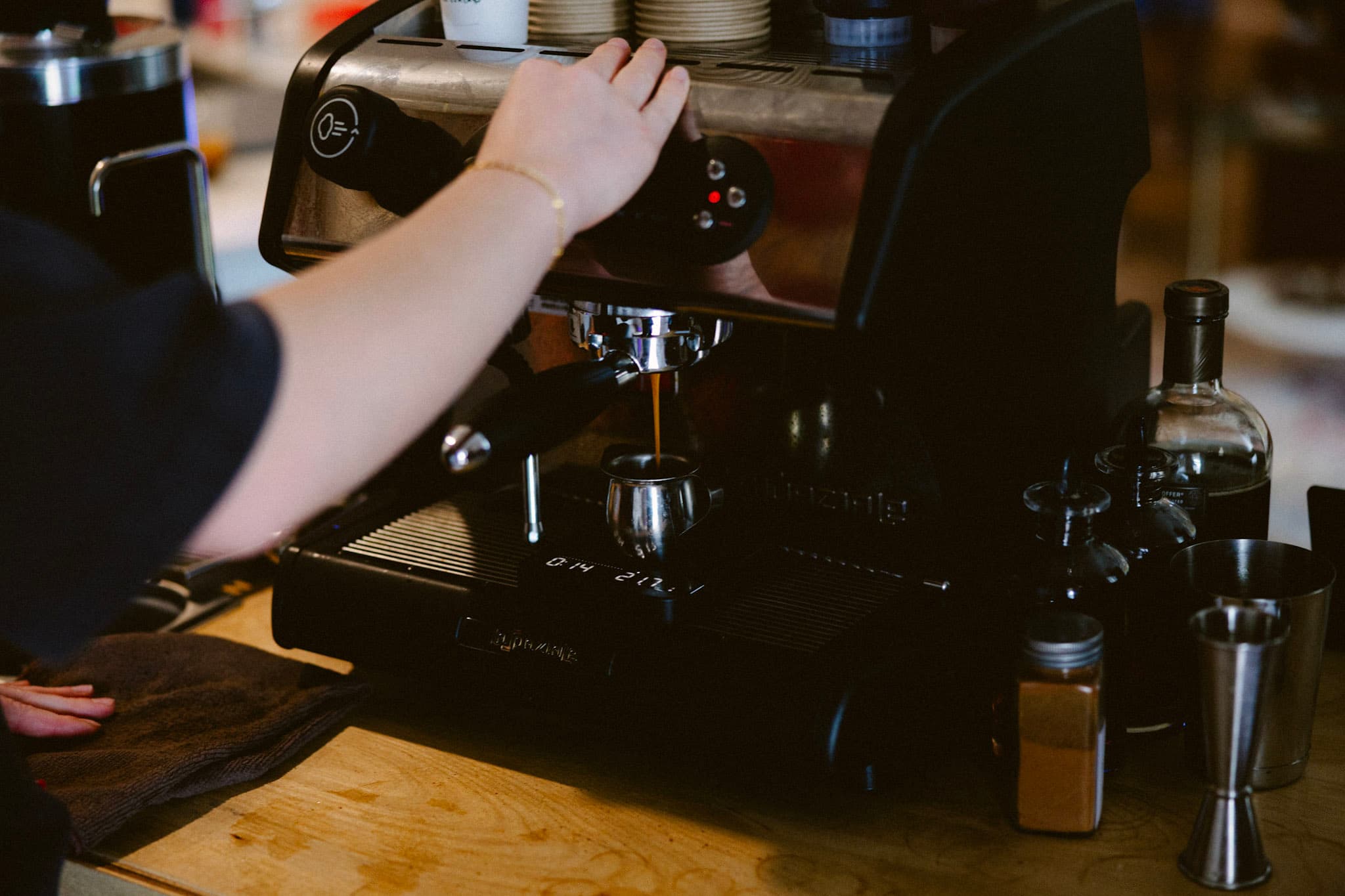 A friendly barista making a latte with a coffee cart