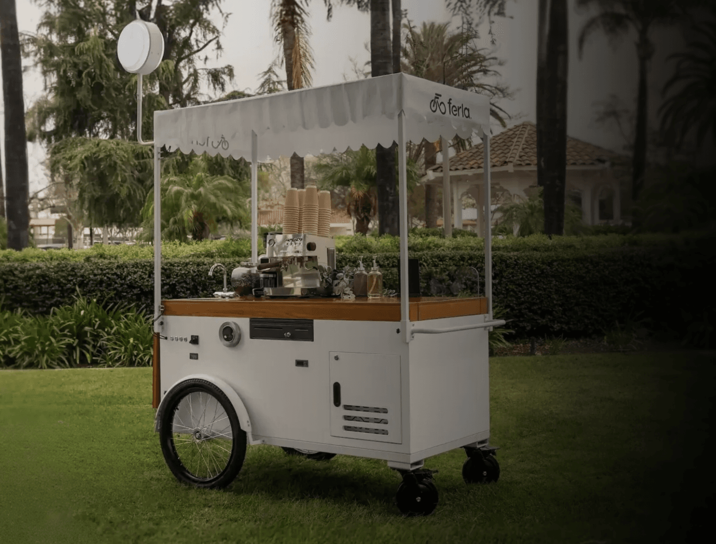 A friendly barista pouring smooth latte art at a coffee cart